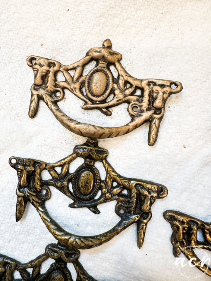 one piece of hardware with bronze paste and one without