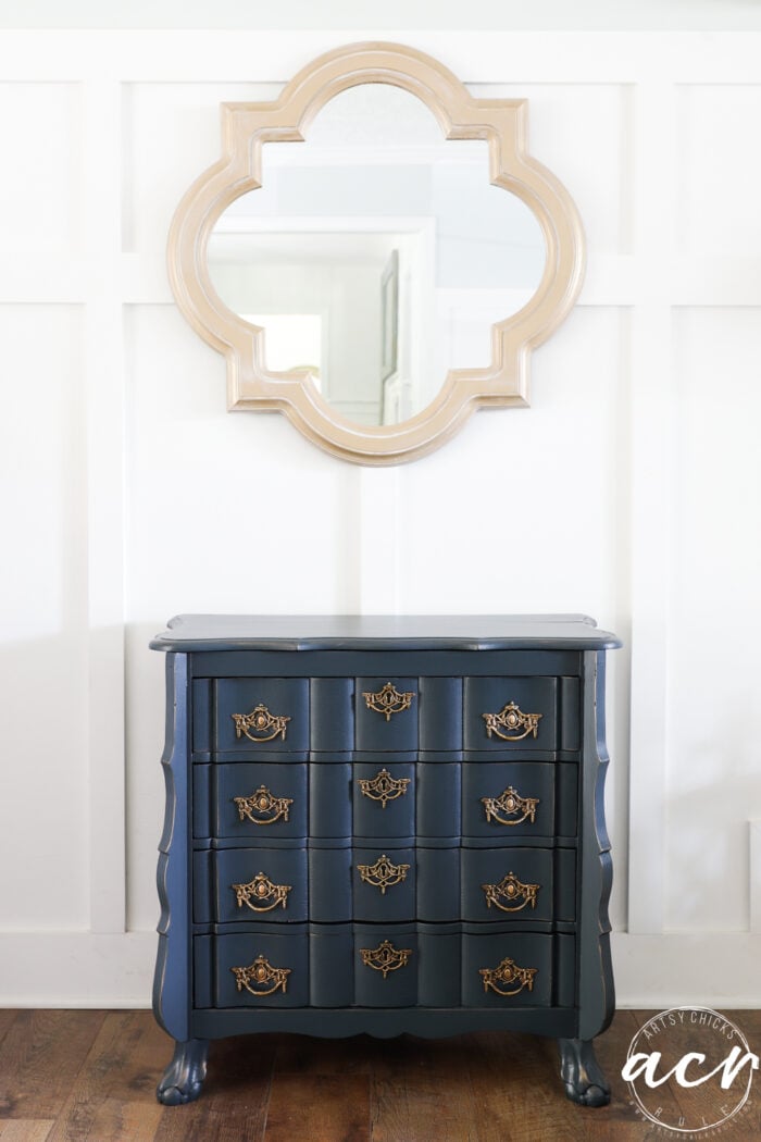 blue dresser with gold hardware under gold mirror