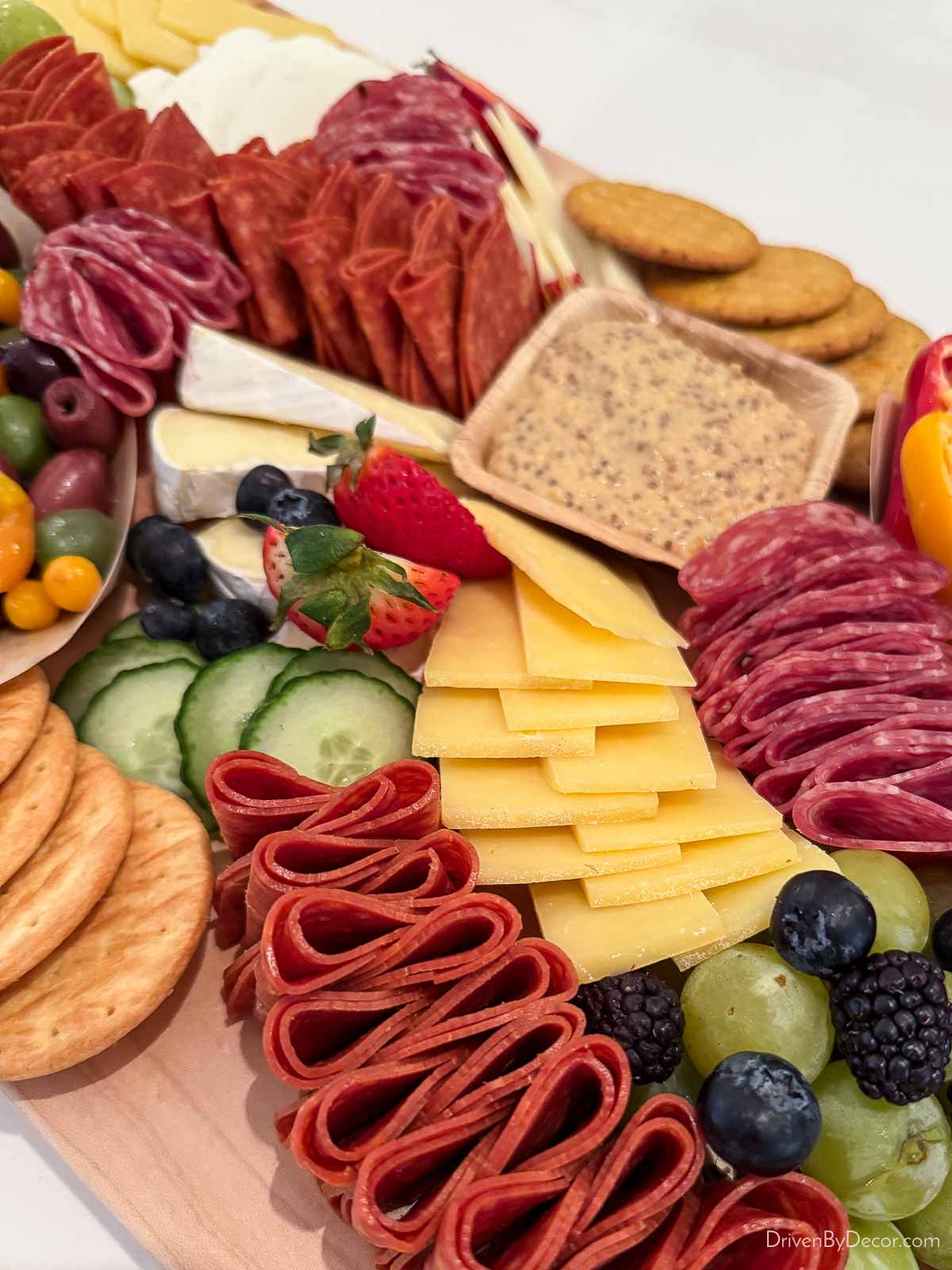 Meats, cheeses, fruit, crackers, and more on a charcuterie board