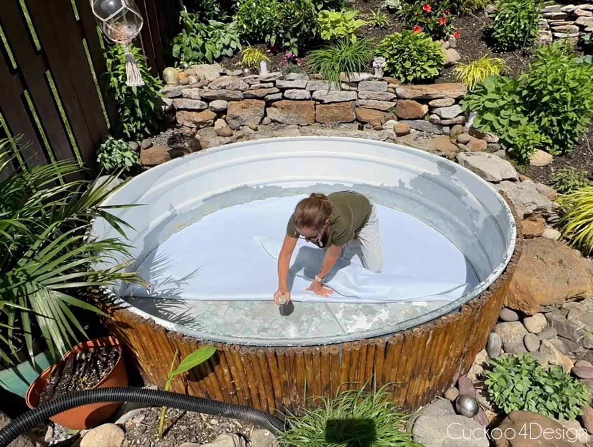 gluing down the pool liner pad to the bottom of the stock tank pool